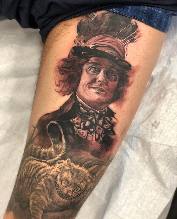 Alice in wonderland mad hatter with cheshire cat thigh tattoo done in black and grey ink by tattoo artist Russ Howie of Sacred Mandala Studio in Durham, NC.